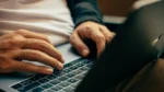 Close up of someone's hands typing on their laptop keyboard